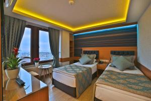 イスタンブールにあるHotel Resitpasa Istanbulのベッド2台とデスクが備わるホテルルームです。