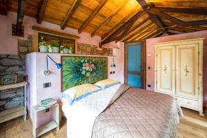 a bedroom with a bed and a painting on the wall at Ca da la Butina in Mergozzo