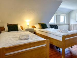 2 Einzelbetten in einem Zimmer mit einer Lampe in der Unterkunft Silbach Panorama Lodge in Winterberg