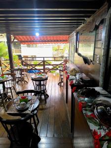 a dining room with tables and chairs and a table with food at Pousada Capim Açu in Fernando de Noronha