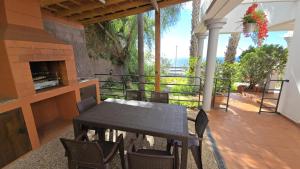 a table and chairs on a balcony with a fireplace at The Garajau Views in Caniço