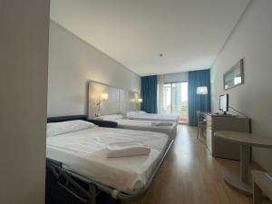 a hotel room with three beds in a room at AGH Canet in Canet de Berenguer