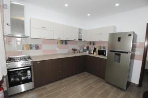 a kitchen with white cabinets and a refrigerator at Casa Tad in Buşteni