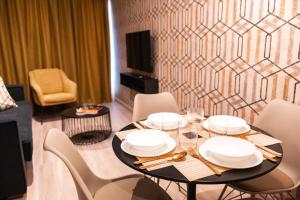 a dining room with a table with white plates on it at Qazris Suites in Cáceres