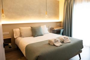 a bedroom with a bed with two towels on it at Qazris Suites in Cáceres