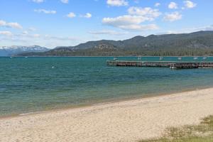 a beach with a pier and mountains in the background at LLC1236 - Lakeside Landing in South Lake Tahoe