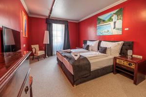 a bedroom with a large bed with red walls at Barka Galéria Hotel és Étterem in Tállya