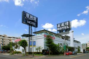高雄的住宿－薇風情汽車旅館 - 自由館，街道边有两个标志的汽车旅馆