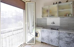 a kitchen with a sink and a large window at Stunning Apartment In Ragusa in Ragusa