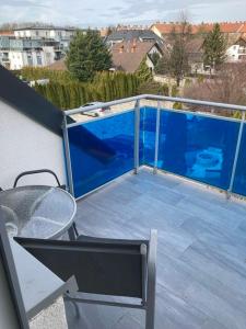 a balcony with a blue deck with a table and chairs at Zöld zafír in Sárvár