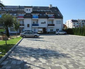 two cars parked in front of a large building at Zöld zafír in Sárvár