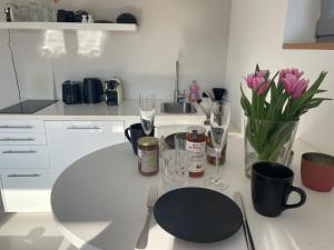 a white kitchen with a table with wine glasses and flowers at Moderne Ferienwohnung in Strandnähe in Surendorf