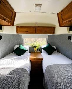 ein kleines Zimmer mit zwei Betten und einem Fenster in der Unterkunft Bonny Airstream in Inver Mallie
