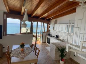 a kitchen with a table and a view of the ocean at Finestra sul golfo in Balestrate