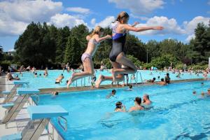 two girls jumping into a swimming pool at Guest rooms, ved Lillestrøm in Lillestrøm