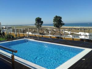 a swimming pool with a view of the ocean at Hotel y Apartamentos Conilsol in Conil de la Frontera