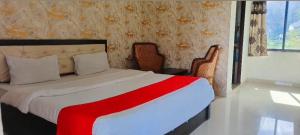 um quarto com uma cama com um cobertor vermelho e branco em The Great Meva Palace Pushkar em Pushkar