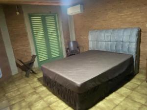 a bedroom with a bed and two green doors at Villa Domus in Barretos