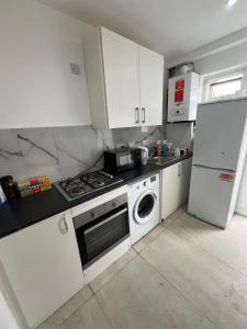 a kitchen with a stove and a refrigerator at Good Priced Single Rooms in East Acton in London