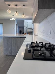 a kitchen with a black stove top in a kitchen at Villa Matthew - Villa de Lujo con Piscina Privada y BBQ, Cerca al Mar in Juan de Acosta