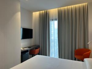 a hotel room with a bed and a desk and a window at Chi in Barcelona