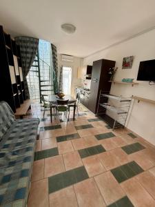 a living room with a table and a kitchen at Casa Vacanza Delfino in Porto Cesareo