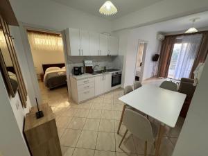 a kitchen with a table and a room with a bed at Comfort Apartments Promenade in Sarandë