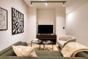 a living room with a couch and two chairs and a tv at ULIV Pulse Roma - Condesa in Mexico City +23 photos