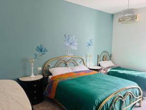 a bedroom with two beds and blue walls at Da Mauro & Michela 2 - XL Apartment - Metro C in Borghesiana 