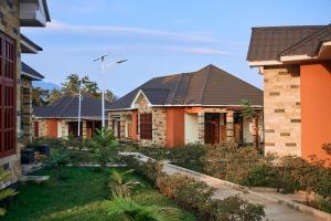 une rangée de maisons avec des toits dans l'établissement Orlando Cottages, à Arusha