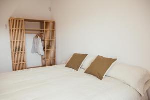 a bedroom with a large white bed with two pillows at Cal Teixidor de Cartellà, Sant Gregori GIRONA in Sant Gregori