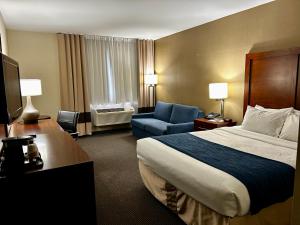 a hotel room with a bed and a chair at Comfort Inn in Saint-Georges