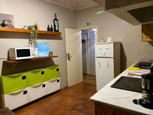 a kitchen with a microwave and a refrigerator at Eco Hostel - Tribo da Praia in Ferrel