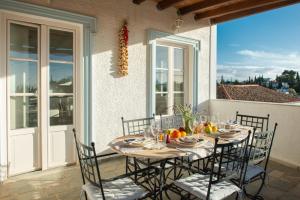 a table on a balcony with a table and chairs at Villa Marilena Spetses - 8 Guests in Spetses