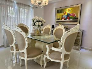 a dining room with a glass table and chairs at Casa en la Autopista de San Isidro in Hainamosa