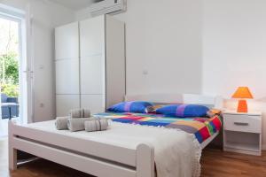 - une chambre blanche avec un lit et une fenêtre dans l'établissement Apartments Filipeti, à Makarska