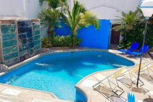 a large swimming pool with chairs and palm trees at Casa Palmare in Manta