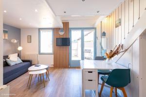 a kitchen and living room with a blue couch at Les Cottages 2 - Maison 4 à 5 personnes au bord de l'océan in Biscarrosse