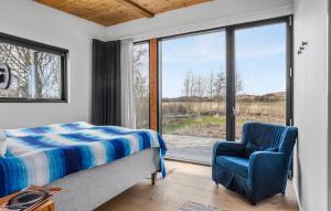 a bedroom with a bed and a chair and a window at Lovely Home In Ebeltoft With Wifi in Ebeltoft +20 photos