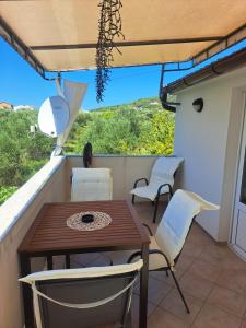 a table and chairs on a balcony with a view at Apartman Sweet Home in Palit