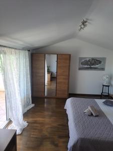 a bedroom with a bed and a large window at Apartman Sweet Home in Palit