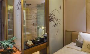 um quarto com um chuveiro, uma cama e uma janela em HUALUXE Hotels & Resorts Nanchang High-Tech Zone, an IHG Hotel em Nanchang