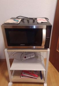 eine Mikrowelle auf einem Regal neben einem Videospiel-Controller in der Unterkunft Bei EDE & Helli in Klotten + 23 Fotos