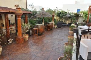 un patio avec des tables, des chaises et des plantes en pot dans l'établissement Krimar Hotel, à San Vito Lo Capo