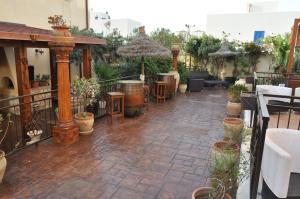 a patio with tables and chairs and potted plants at Krimar Hotel in San Vito lo Capo