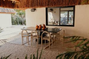 a dining room table and chairs in front of a house at Ixum, Casa Hotel Boutique in Cancún