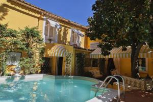 a swimming pool in front of a yellow building at Palazzo Cherubini-Pools & Wellness in Rossano