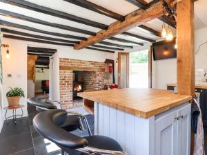a kitchen with a counter and chairs in a room at 1 Harpur Cottage in Bedford
