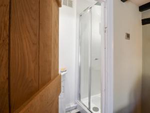 a bathroom with a shower with a glass door at 1 Harpur Cottage in Bedford