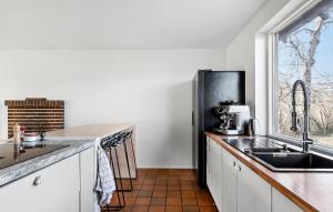 a kitchen with a sink and a refrigerator at 5 Bedroom Beautiful Home In Gilleleje in Gilleleje